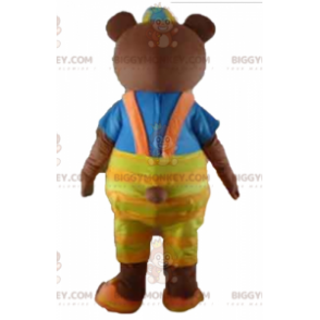 Ruskea karhu BIGGYMONKEY™ maskottiasu keltaisilla haalareilla